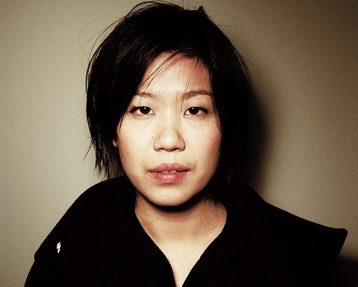 Person with short hair in dark clothing.