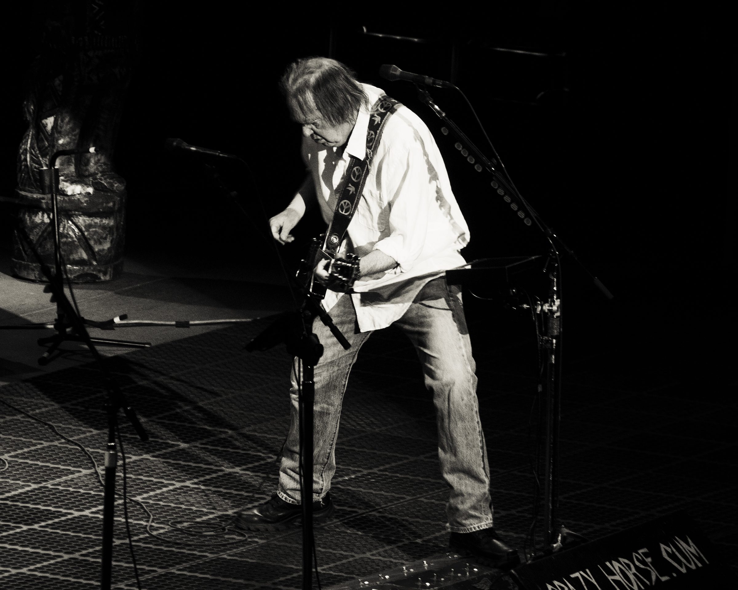 Guitarist performing energetically on stage, black and white.