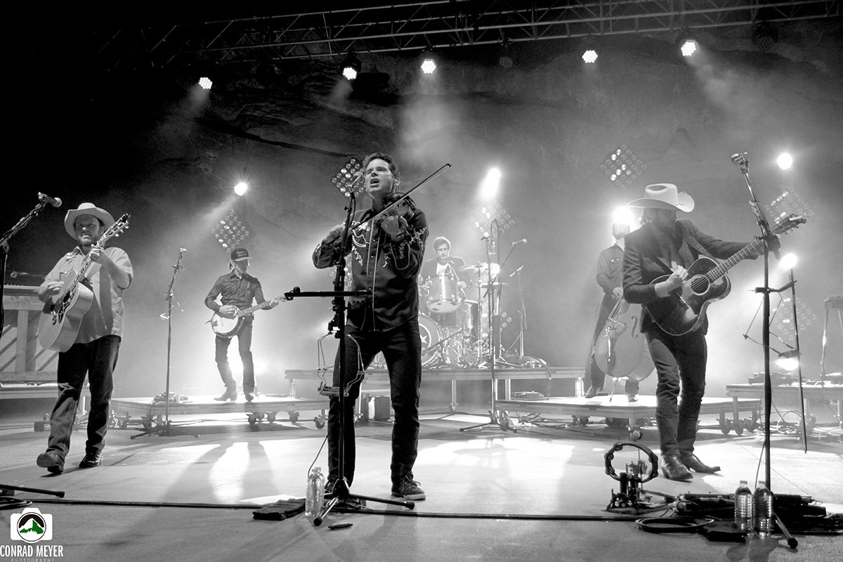 Band performing live on stage, black-and-white.