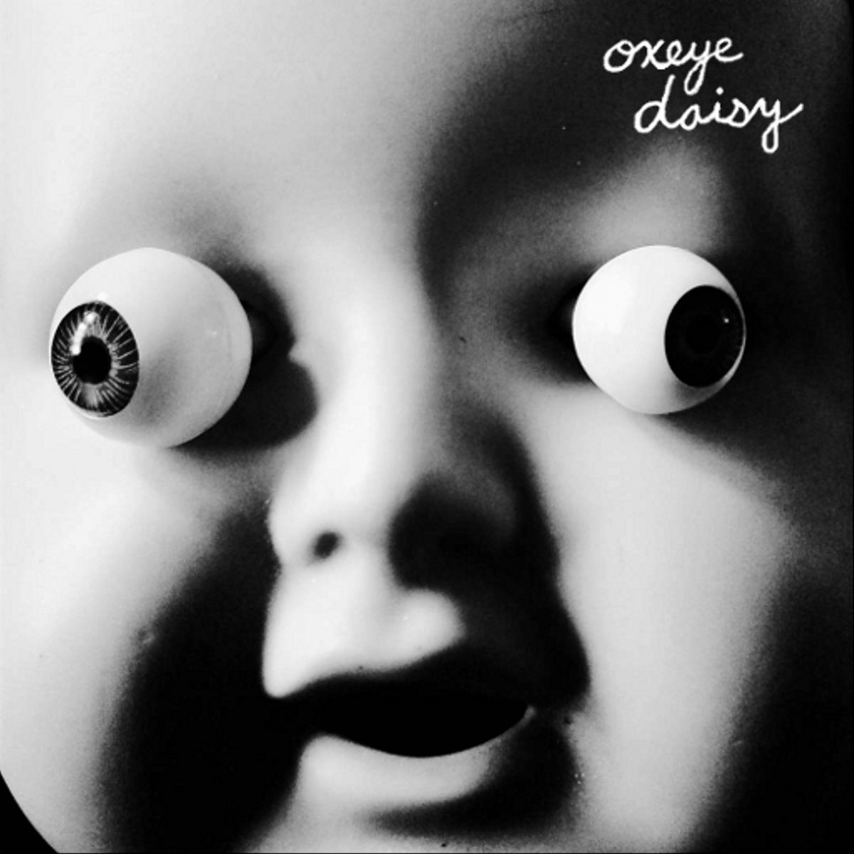 Surreal doll face with exaggerated eyes.
