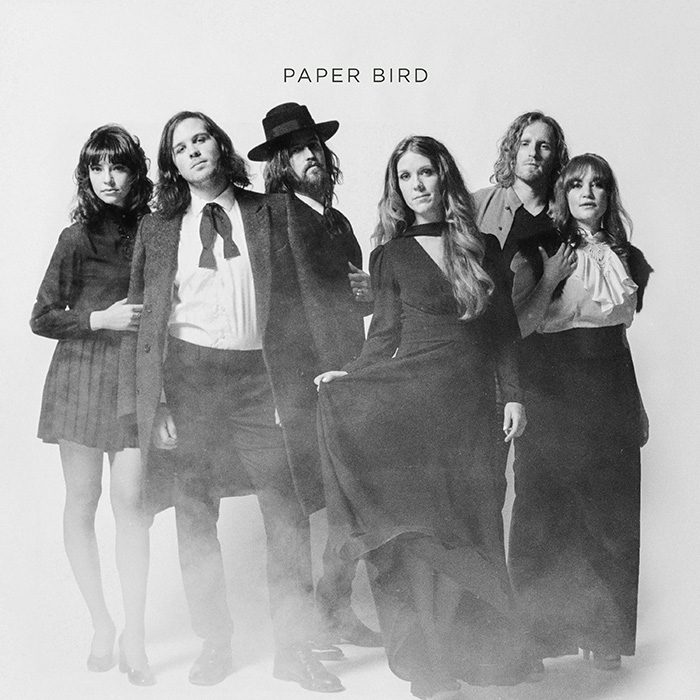 Group of six people in vintage clothing.
