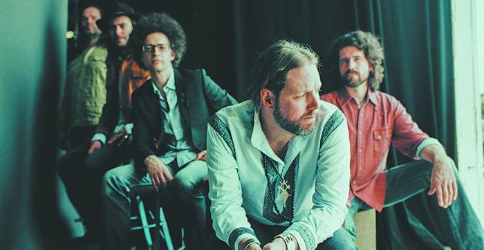 Band members sitting in a dimly lit room.