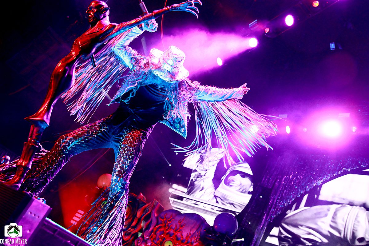 Performer in vibrant costume on stage, dancing.