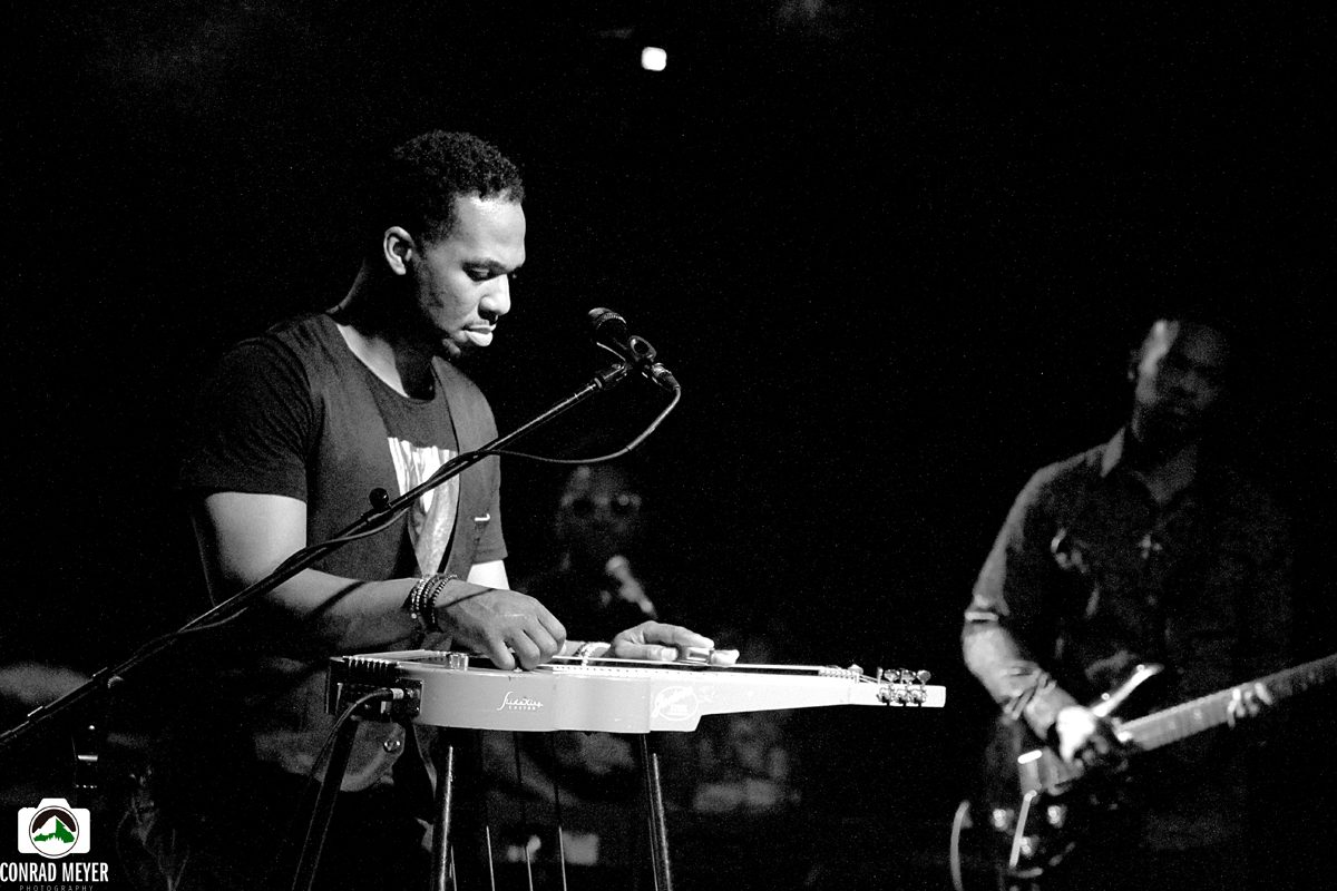 Musicians performing on stage in black and white.
