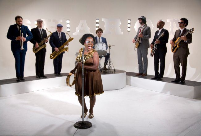Band performing with singer and musicians on stage.