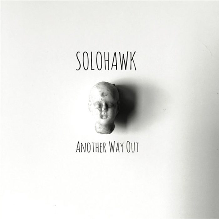 Album cover with a small sculpted head.