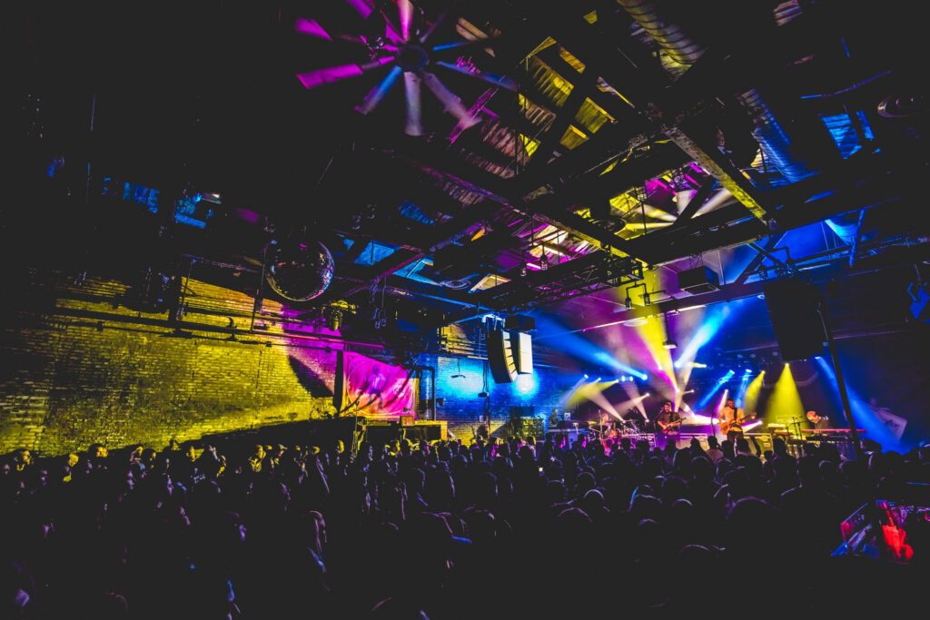 Concert with colorful stage lights and crowd.