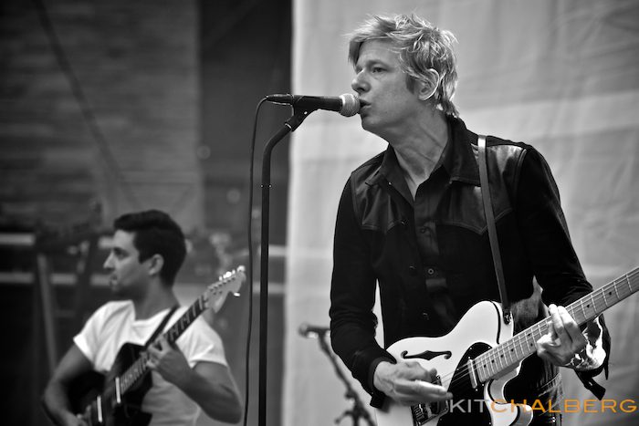 Musicians performing on stage with guitars.