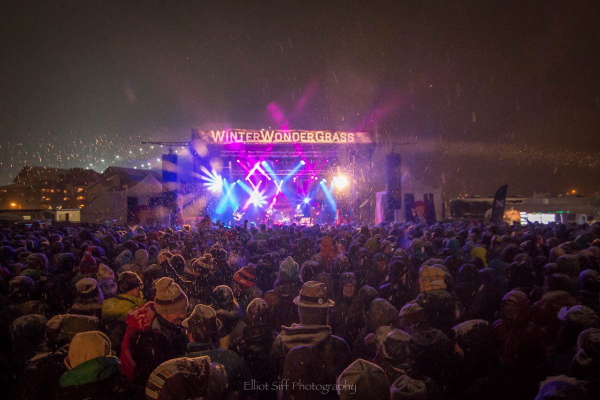 Outdoor concert with colorful stage lights.