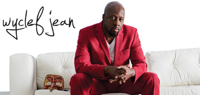 Man in red suit sitting on white couch.