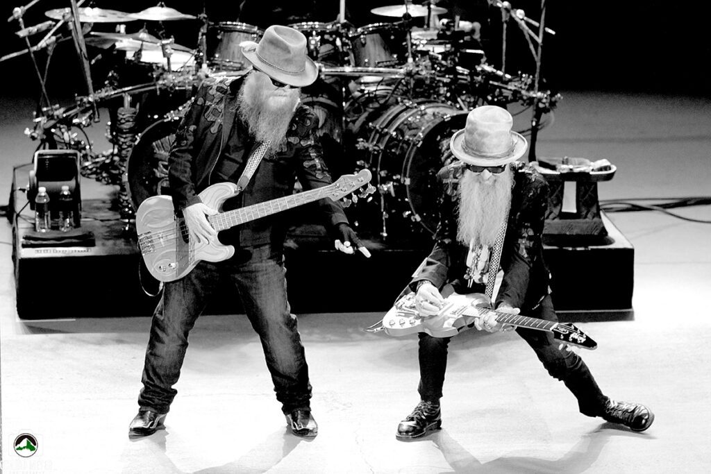 Two musicians performing with guitars on stage.
