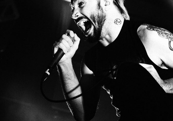 Singer passionately performing on stage, black-and-white.