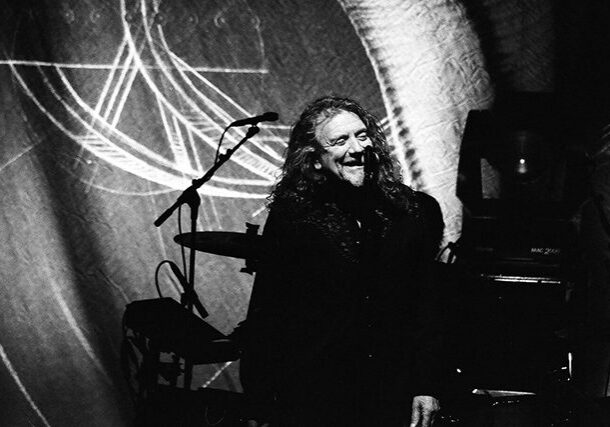 Musician performing on stage in black and white.