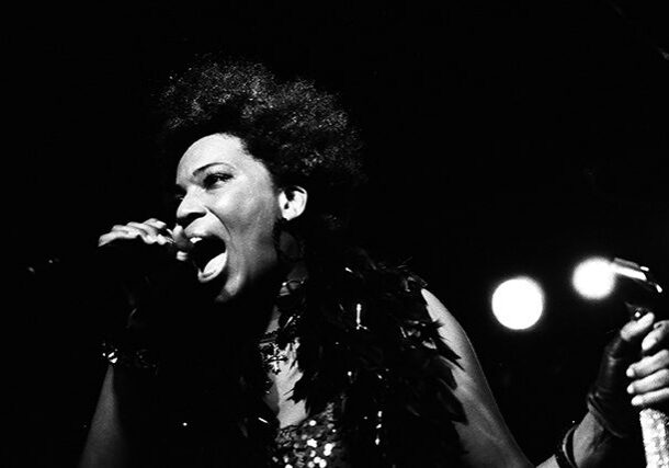 Singer passionately performing on stage, monochrome.