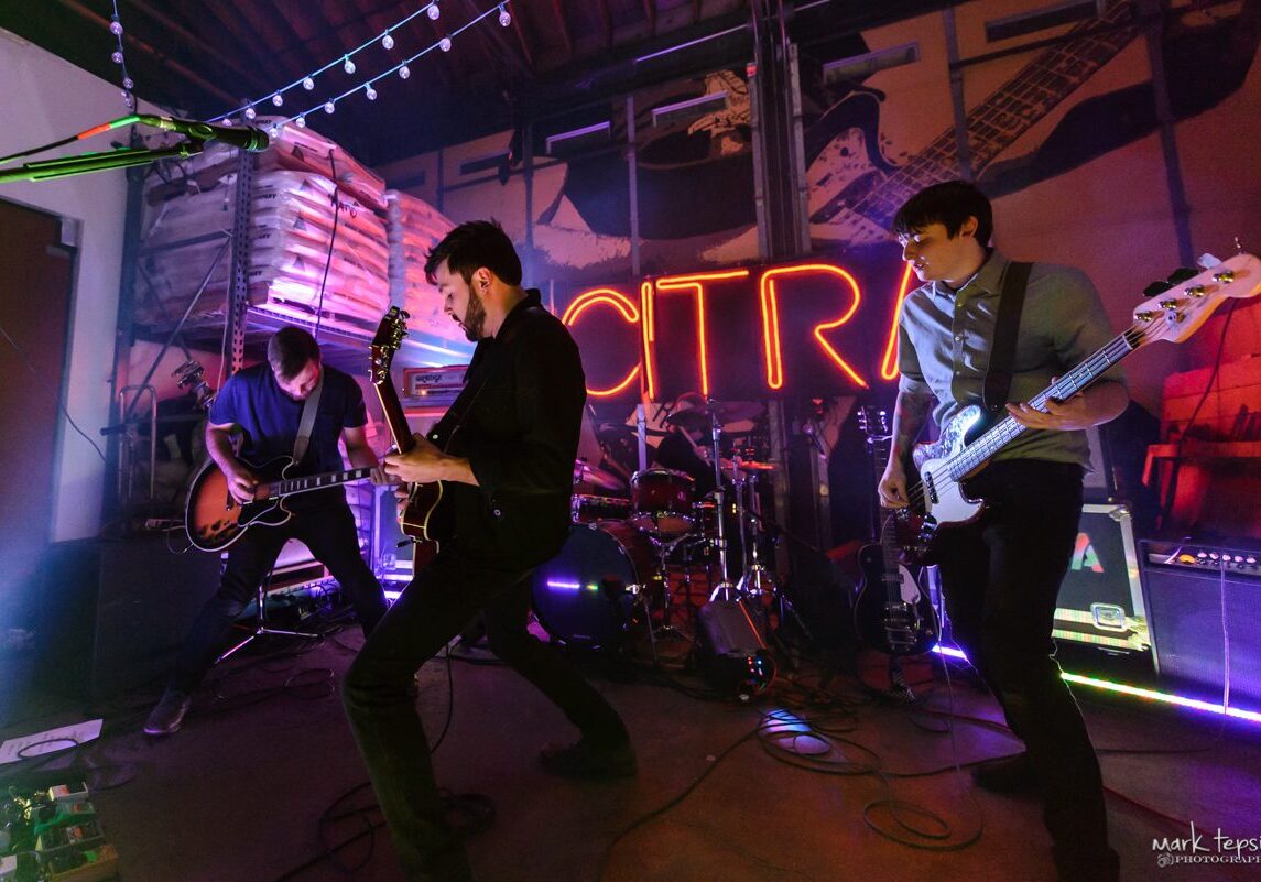 Band performing live on a dimly-lit stage.
