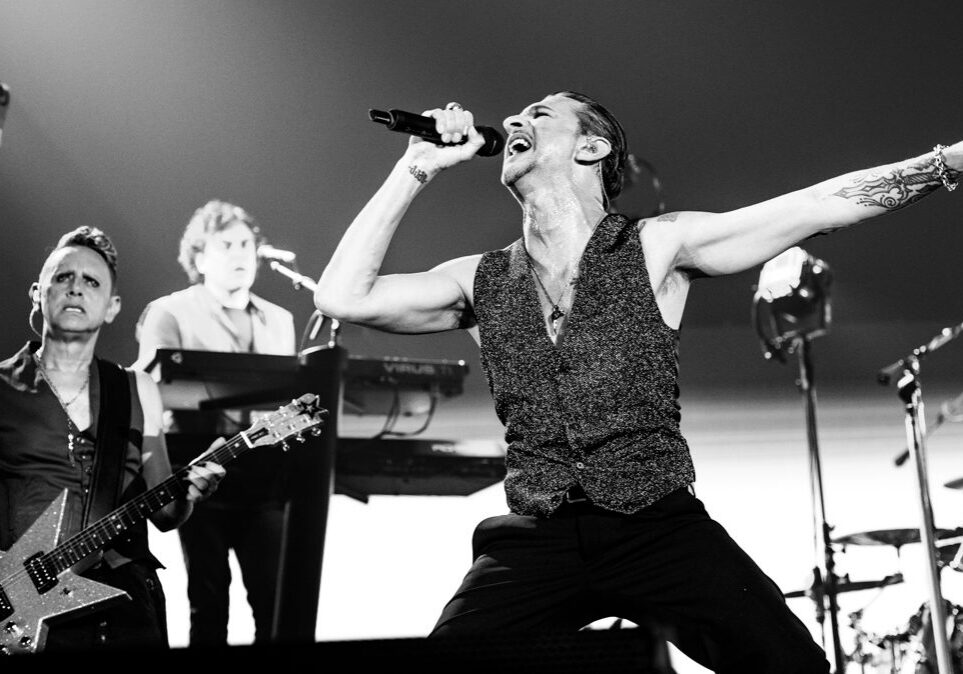 Band performing energetically on stage, black and white.