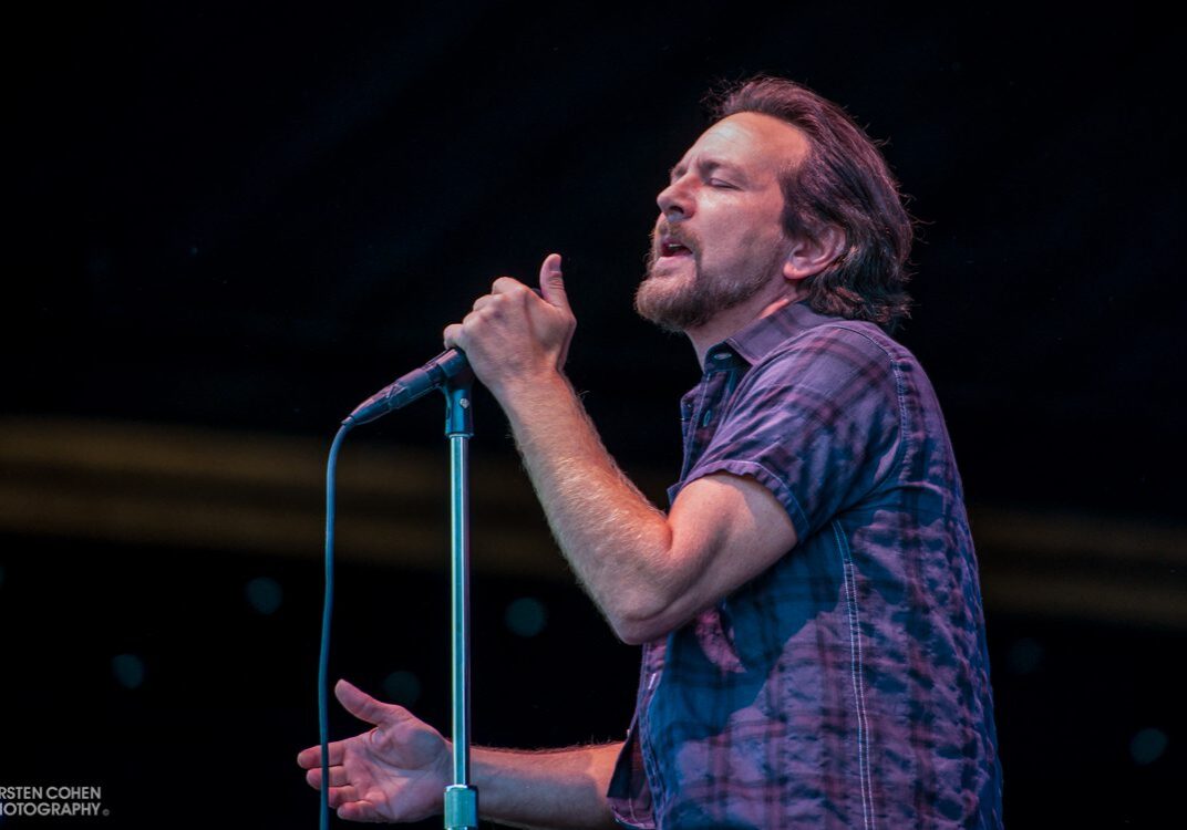 Singer performing passionately on stage with microphone.