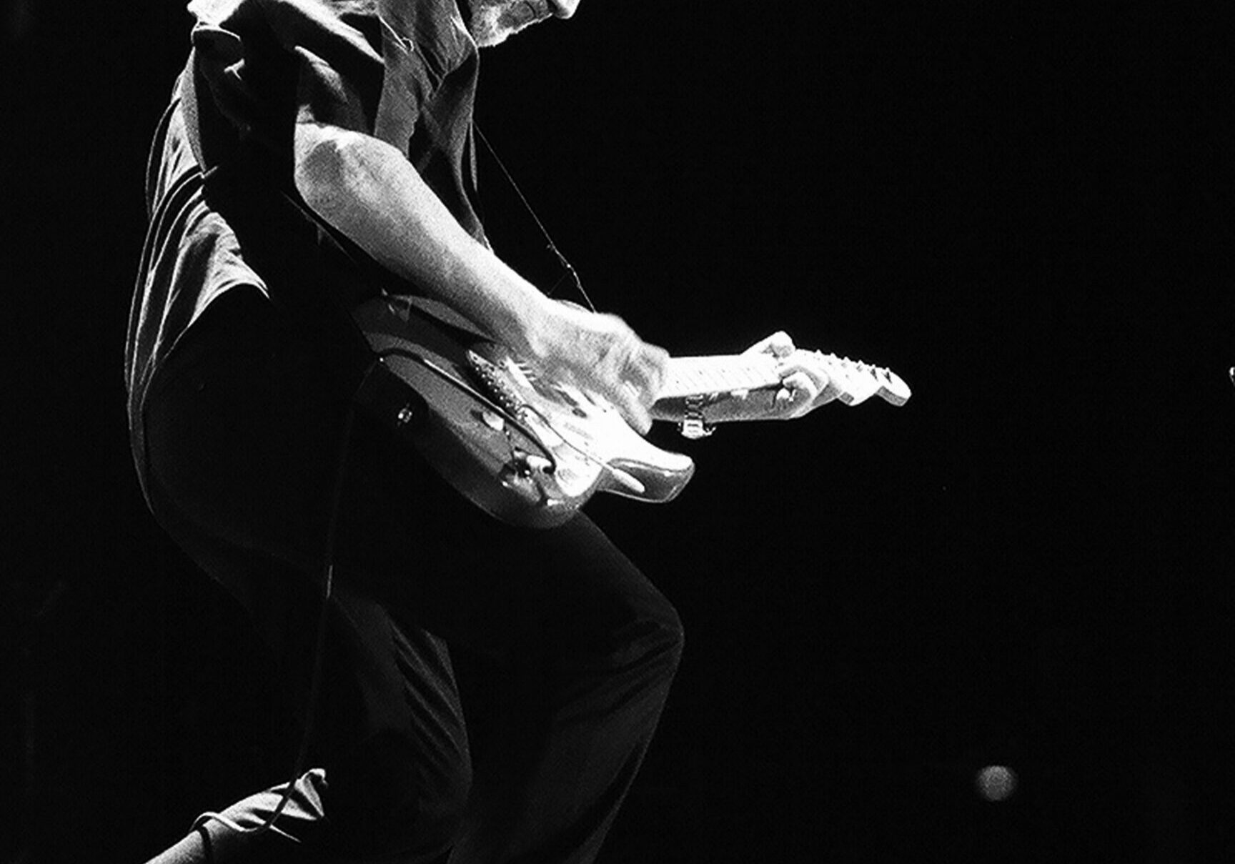 Guitarist passionately playing electric guitar on stage.