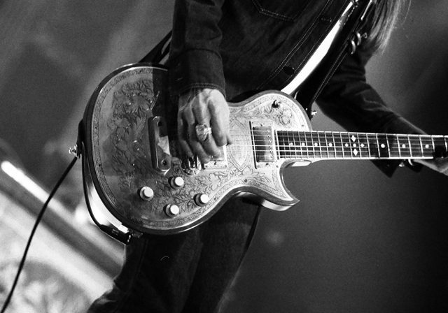 Guitarist playing electric guitar on stage.