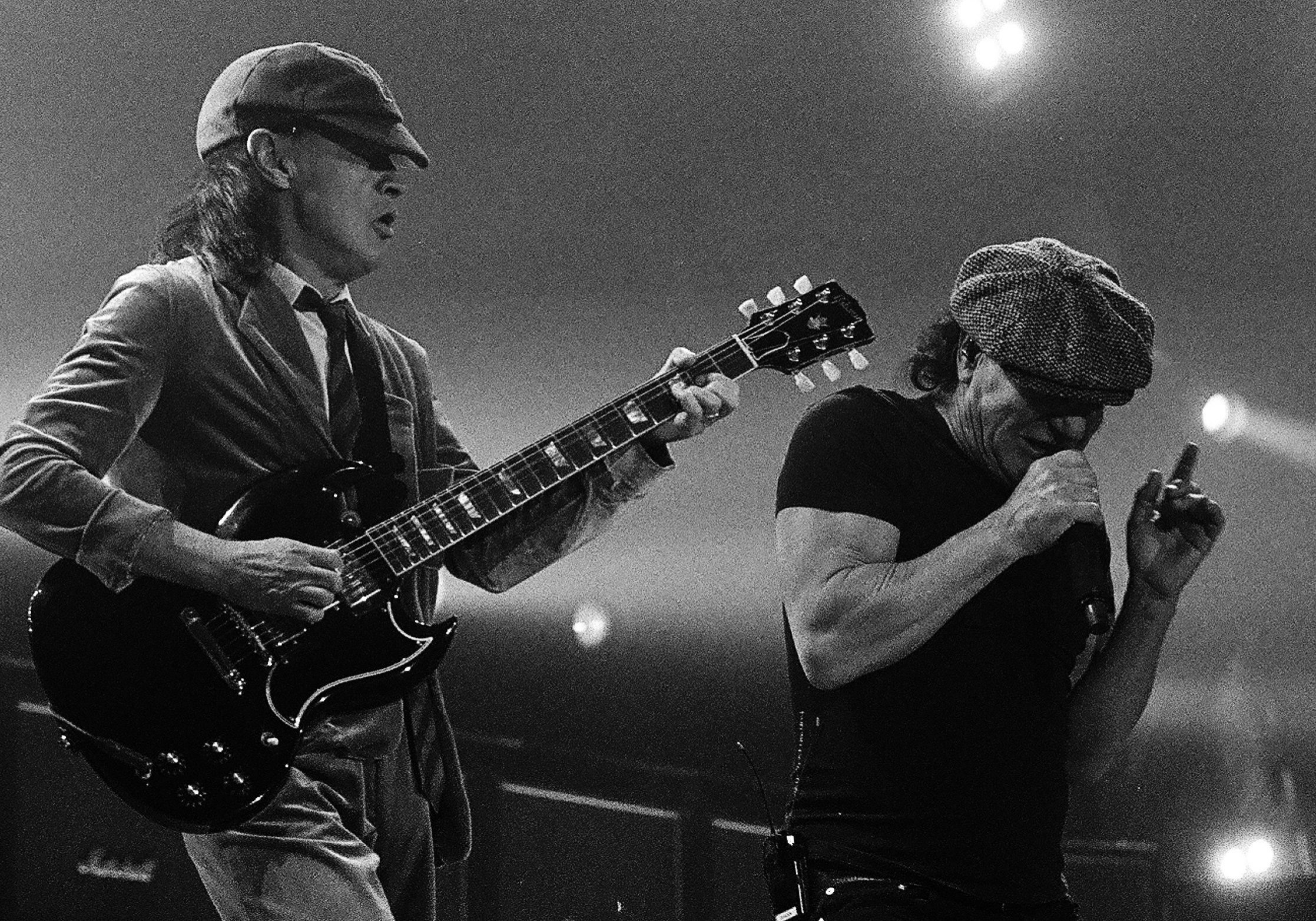 Two musicians performing on stage, black and white.