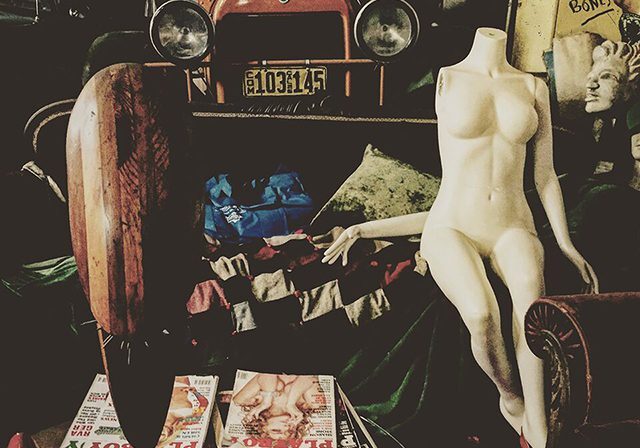 Vintage mannequin and car in eclectic room.