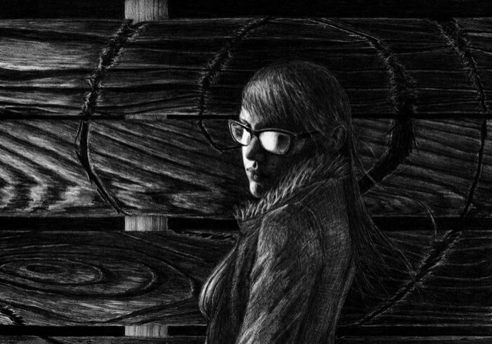 Woman in glasses against wooden background.