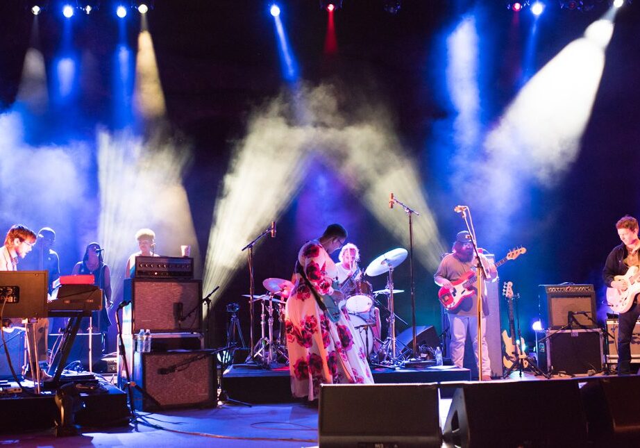 Band performing on stage with colorful lights.