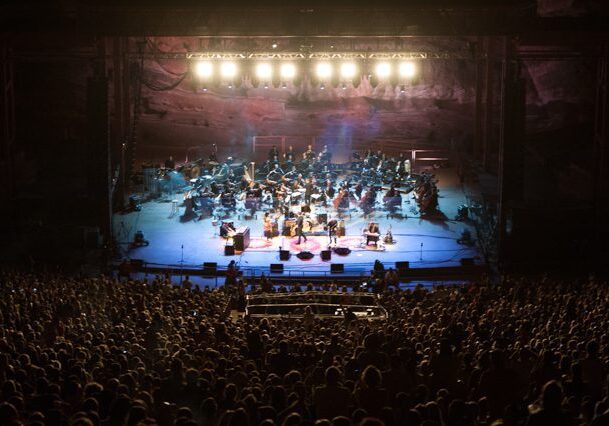 Concert orchestra performing at outdoor venue.
