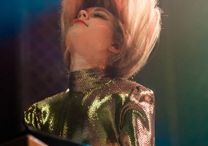 Musician performing energetically on stage.