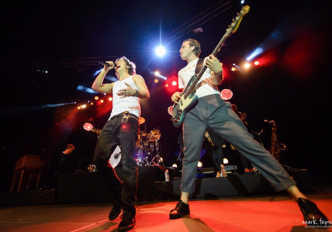 Live band performing energetically on stage.