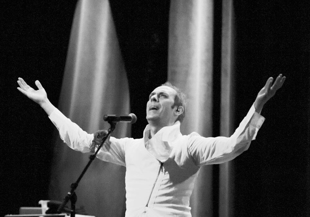 Performer on stage with arms raised.