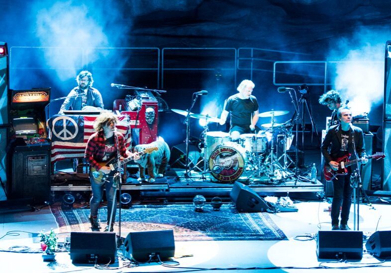 Band performing on stage with colorful lights.
