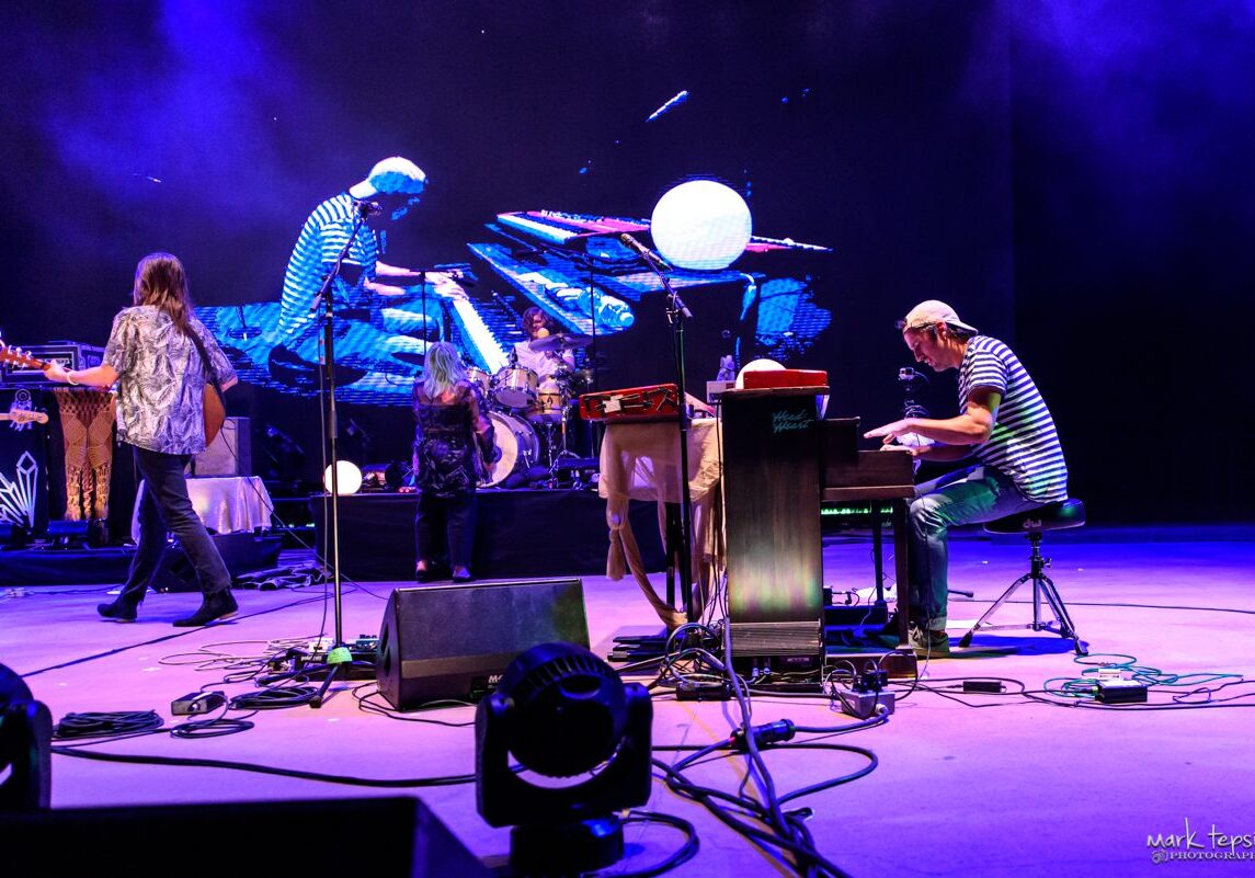 Musicians performing on stage with instruments.