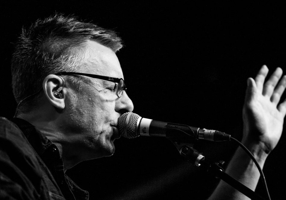 Singer performing on stage with microphone.