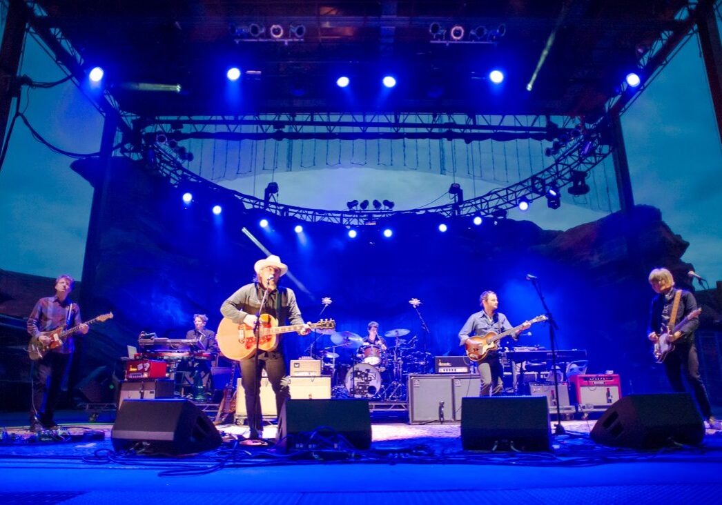 Band performing on an outdoor stage at night.