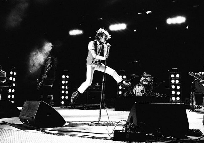 Rock band performing energetically on stage.