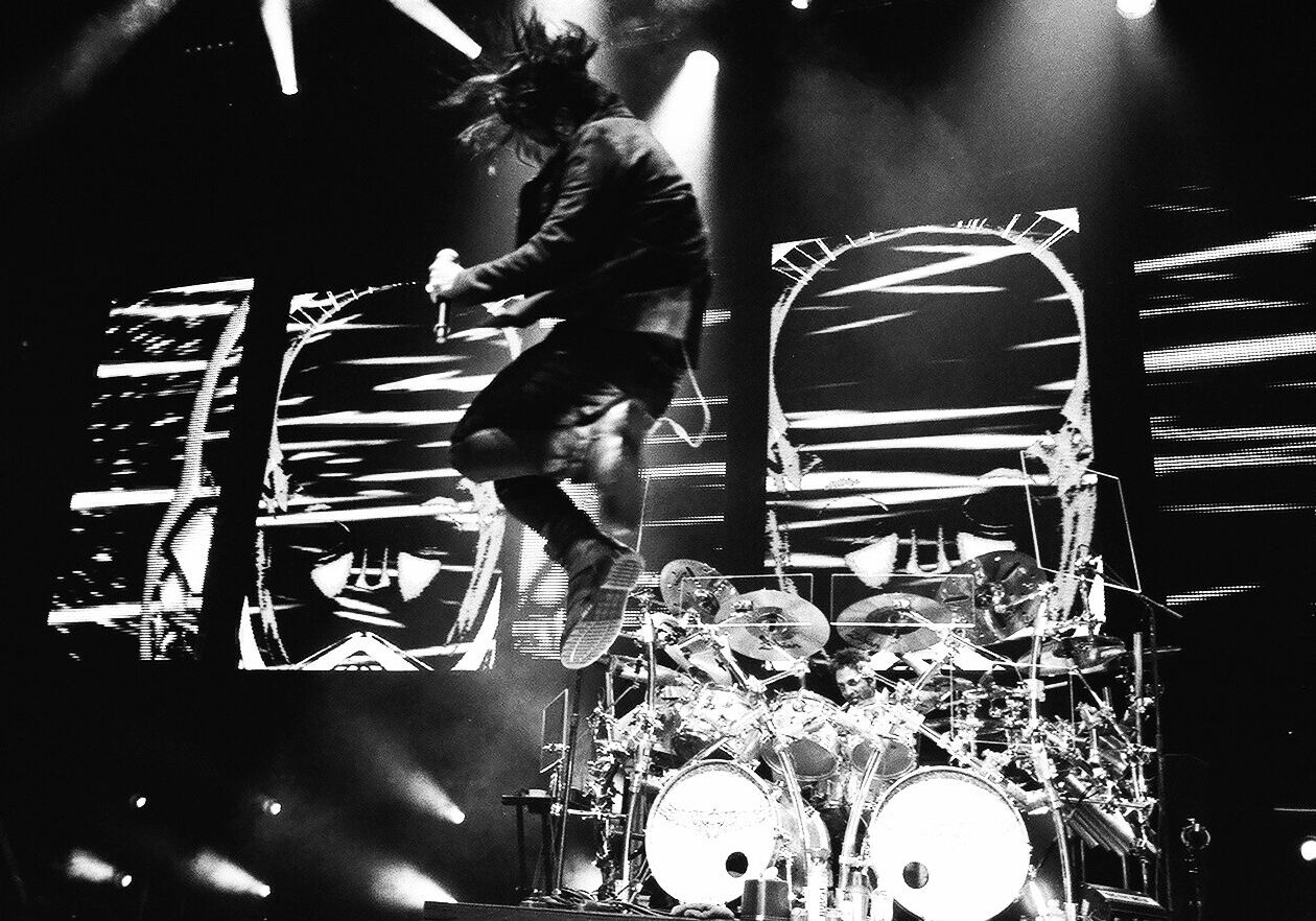 Musician jumping energetically during a live concert.
