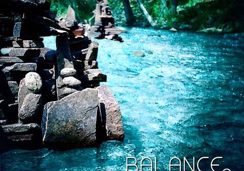 Stacked stones by a flowing river.