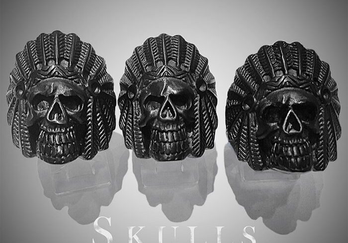 Three skull rings with intricate headdress designs.