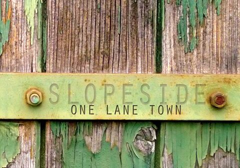Weathered wood with "Slopeside One Lane Town.