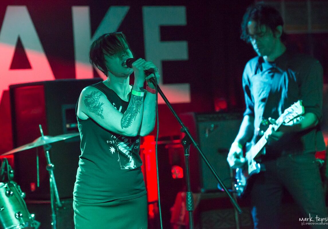 Singer and guitarist performing on stage.