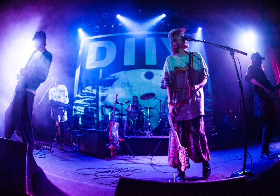 Band performing on stage with colorful lighting.