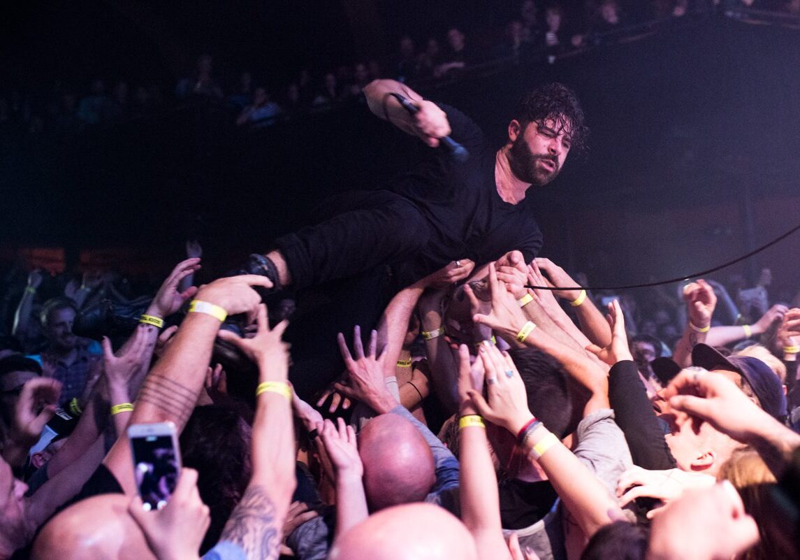 Singer crowd surfing during a live concert.