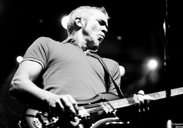 Guitarist performing on stage in black and white.