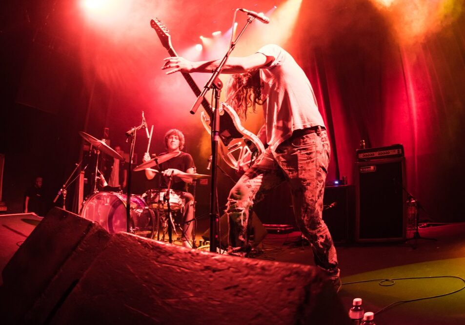 Rock band performing energetically on stage.