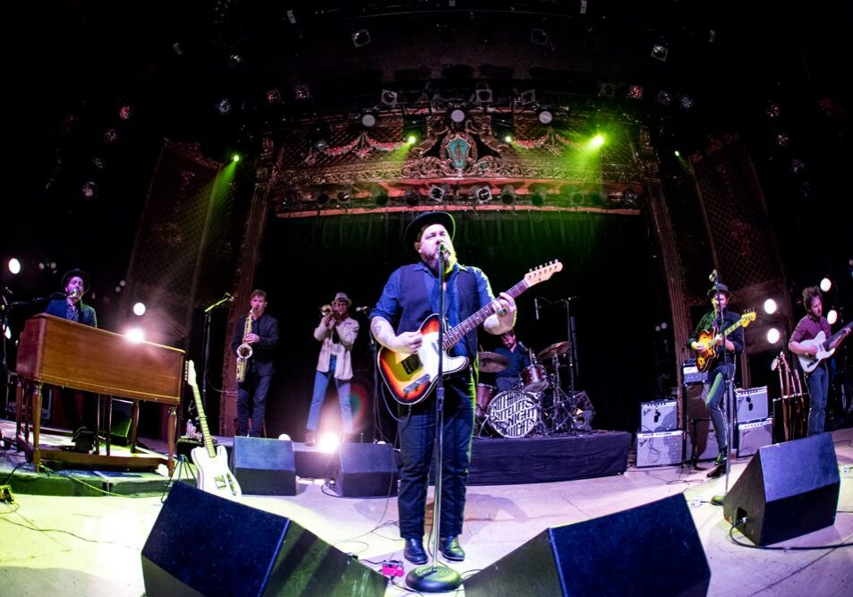 Band performing on stage with instruments.