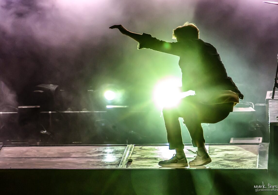 Performer on stage with dramatic lighting effect.