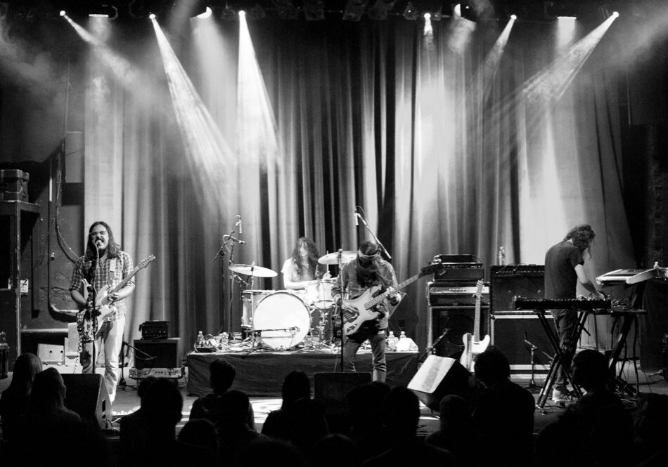 Band performing on stage with instruments.