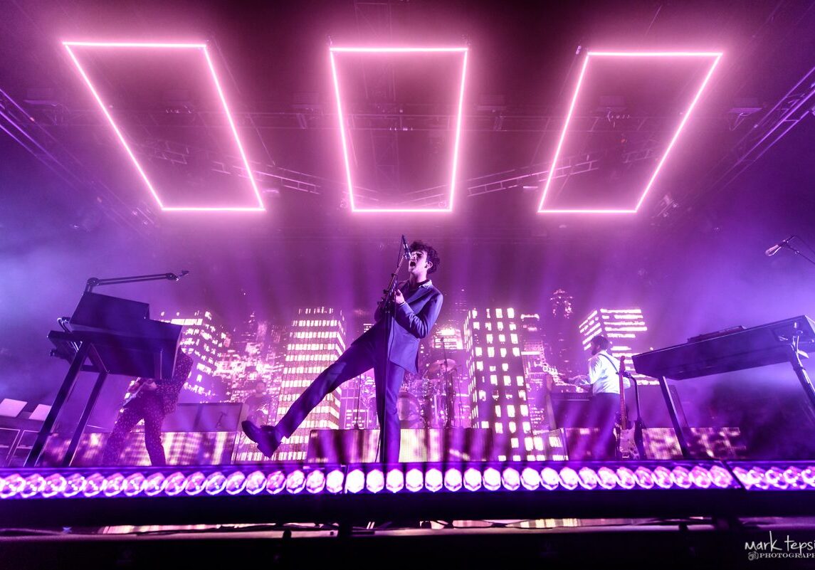 Concert stage with vibrant purple lighting effects.