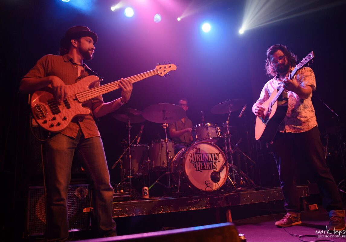 Band performing on stage with colorful lights.